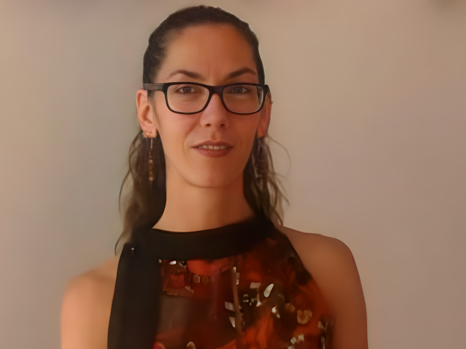 Melani Cubero, sentada a la mesa de su consulta, mira a cámara.
